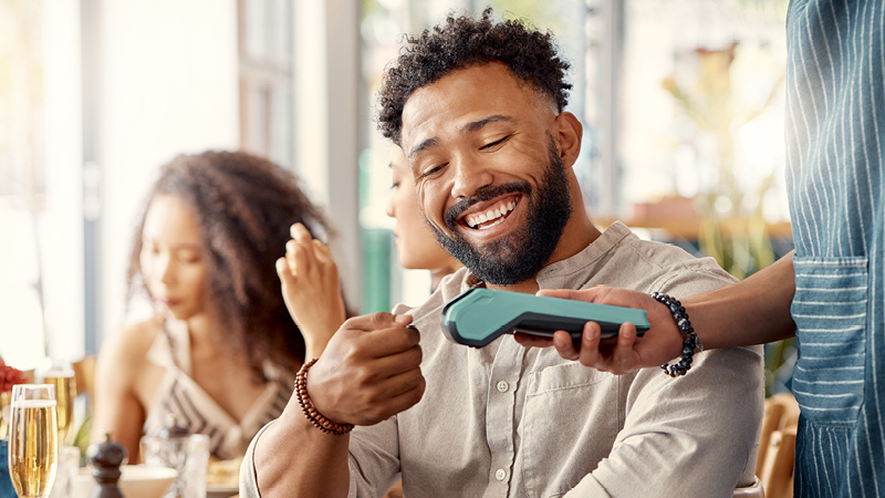 Person making a contactless payment in restaurant