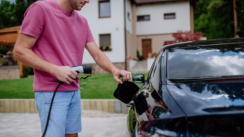 Person connecting electric charger to car