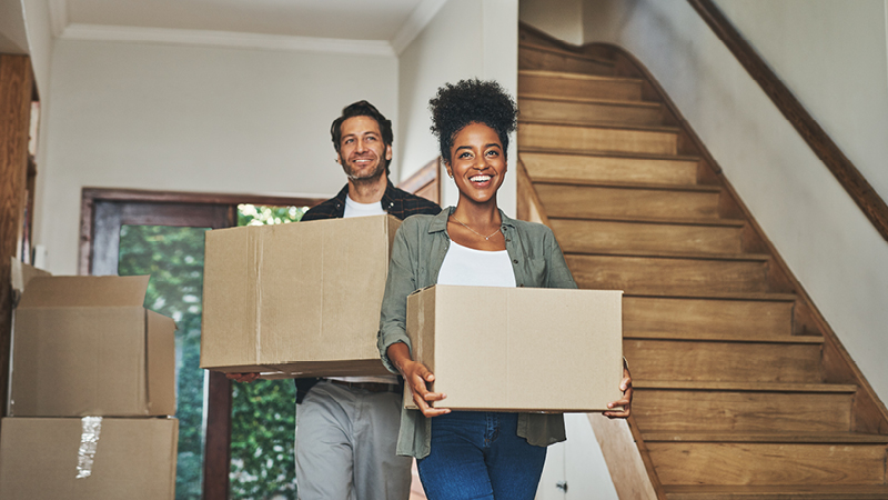 Couple moving boxes into home