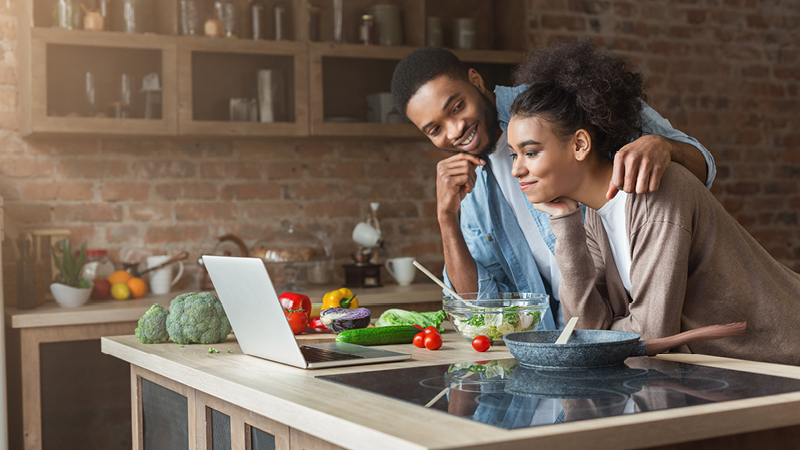 Couple at table looking at laptop