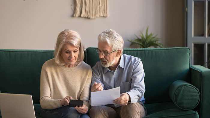 Couple sat on couch reviewing finances together