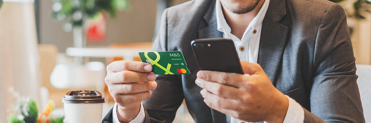 person holding Credit Card and mobile