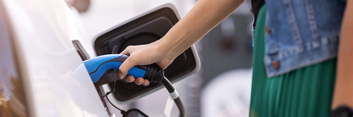 Person connecting electric charger to car
