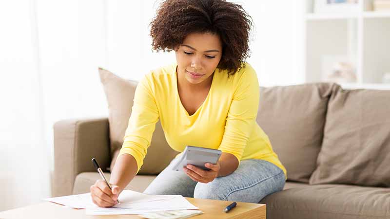 Person on sofa with calculator