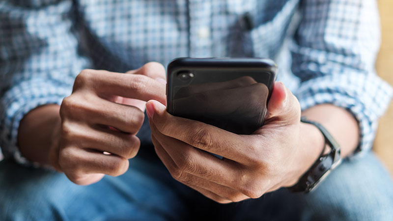 holding mobile phone sat down