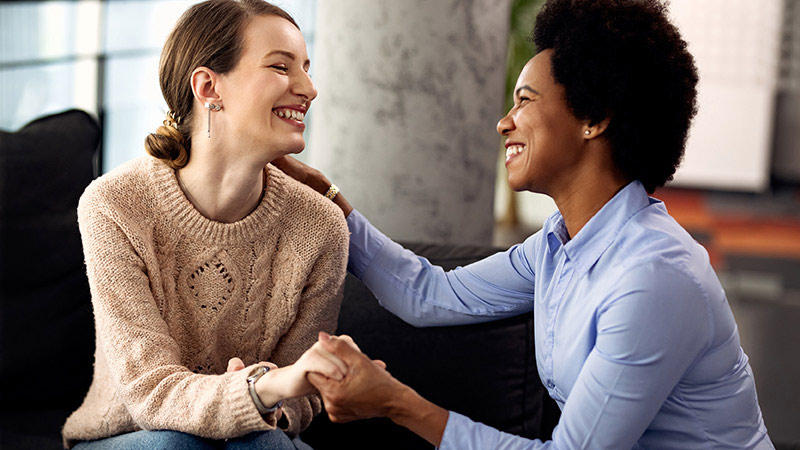 two women smiling and showing support for each other
